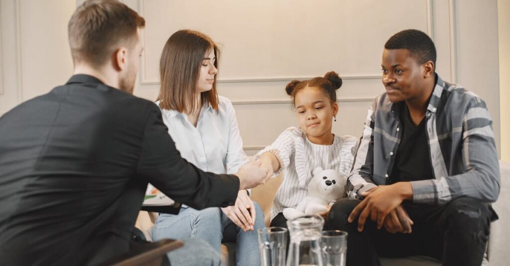 A family in a thoughtful counselling session with a professional in a modern setting.